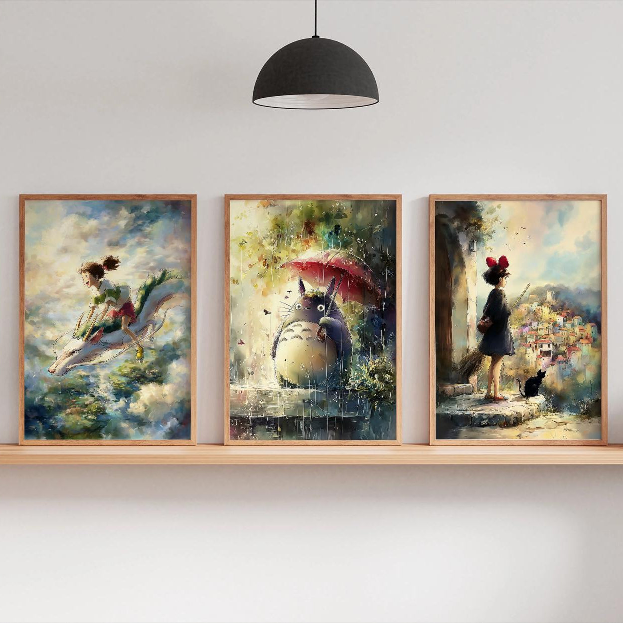 Three framed artworks on a wall shelf with a lamp and plants in the background.