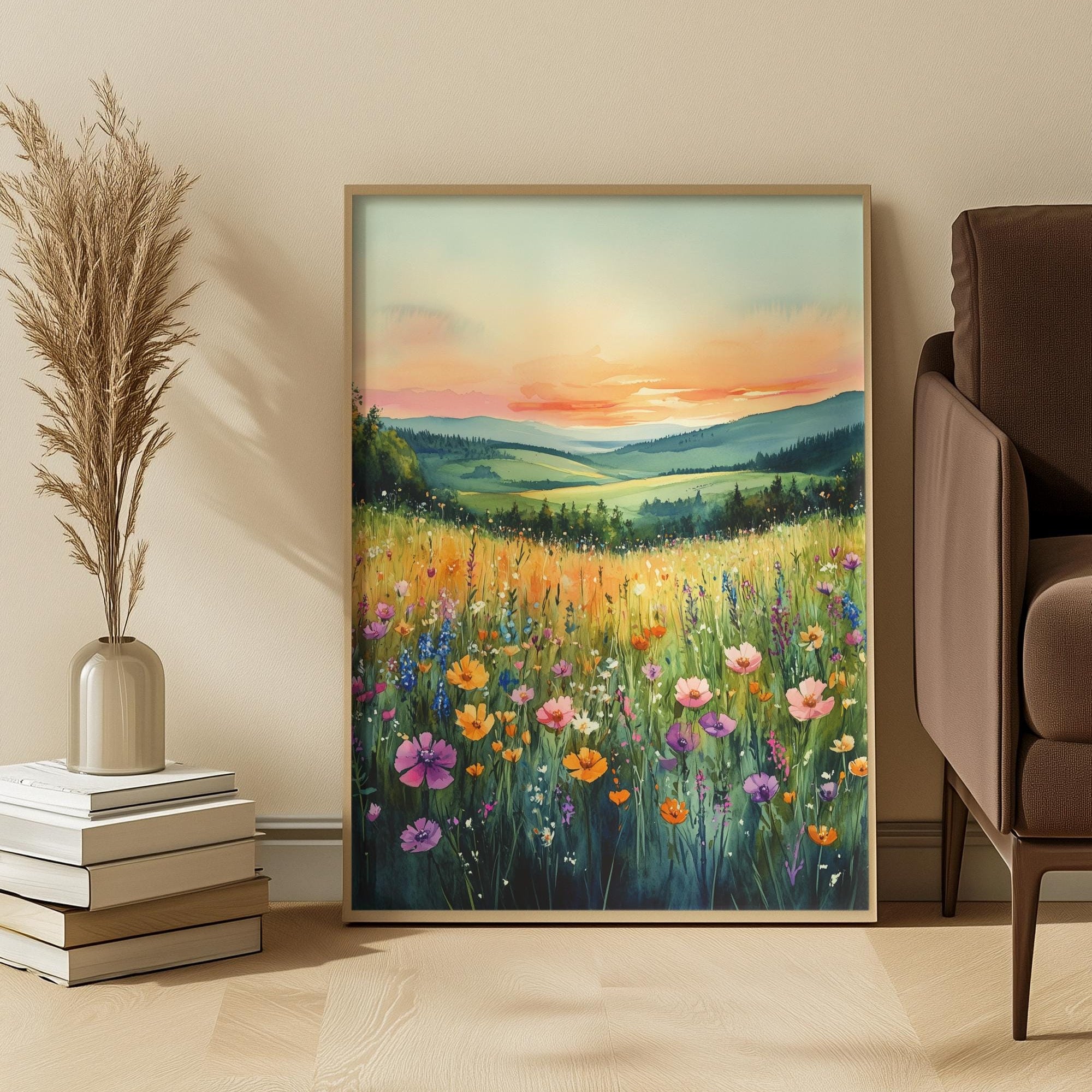 Framed painting of a sunset over a field with flowers in a room with a sofa and decor items.