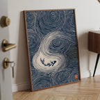 A framed art print featuring a navy blue and white wave design with a koi fish, leaning against a white wall on a light wood herringbone floor.