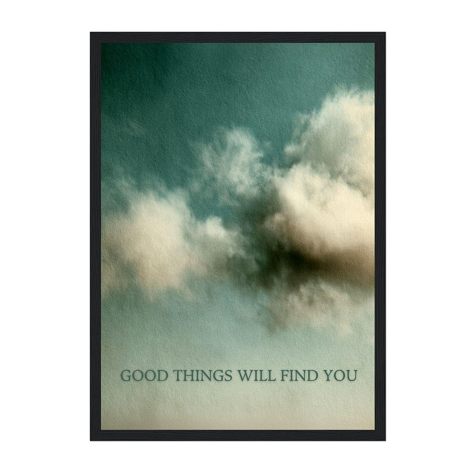A framed art print featuring a textured teal and cream sky with dramatic clouds, and the text 'GOOD THINGS WILL FIND YOU' printed at the bottom. The print is housed in a thin black frame and is centered on a solid white background.
