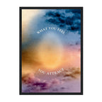 A framed art print featuring a watercolor-style sky with blue, purple, and warm golden tones, with the text 'WHAT YOU FEEL YOU ATTRACT' arched across the center, shown on a white background.