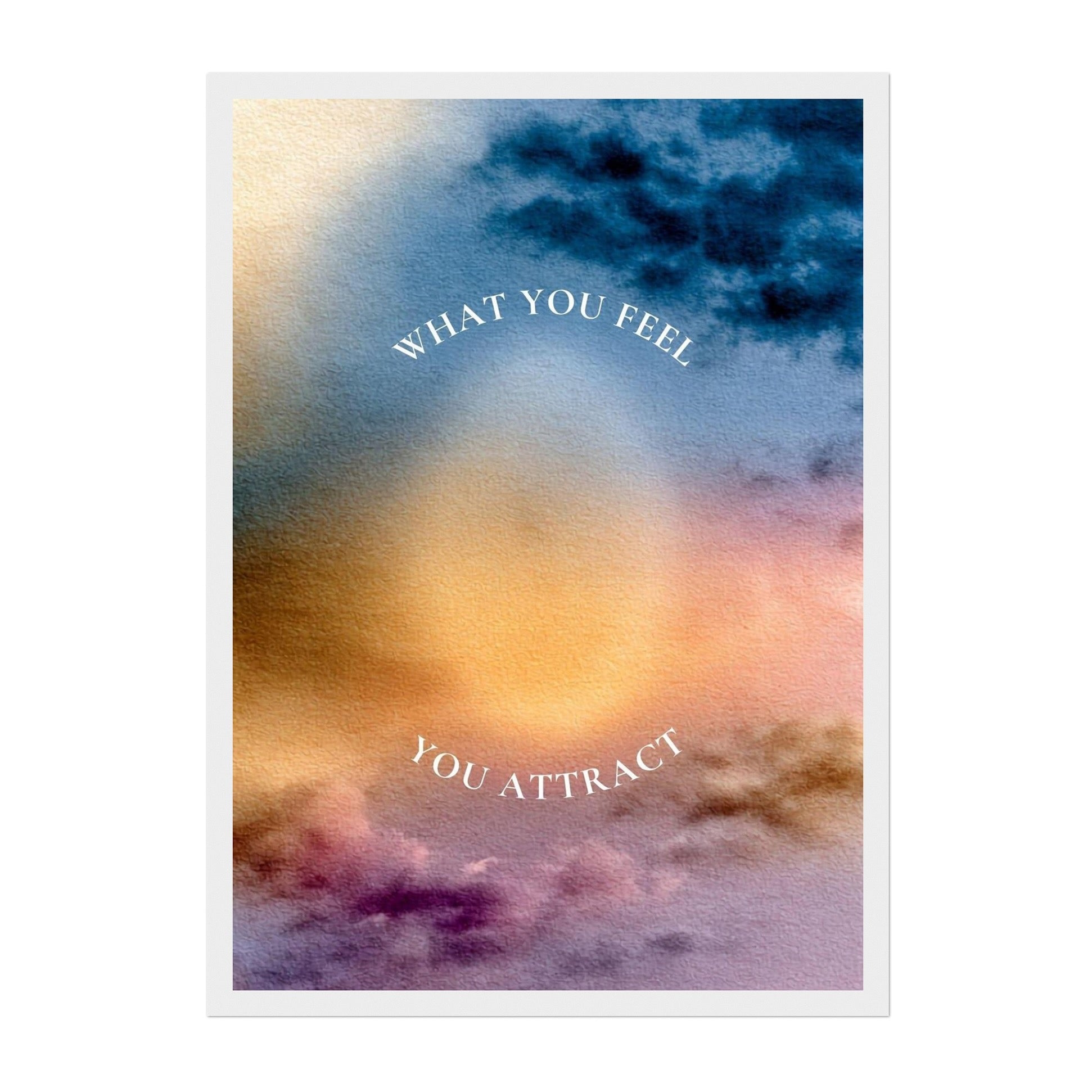 A square art print with a white border featuring an abstract watercolor sky design in blue, gold, orange, and purple hues, with the text 'WHAT YOU FEEL YOU ATTRACT' arched in white lettering.